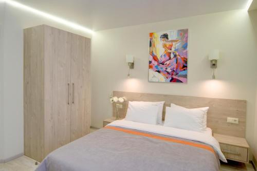 1 dormitorio con 1 cama grande y una pintura en la pared en Arena Apartments, en Kiev
