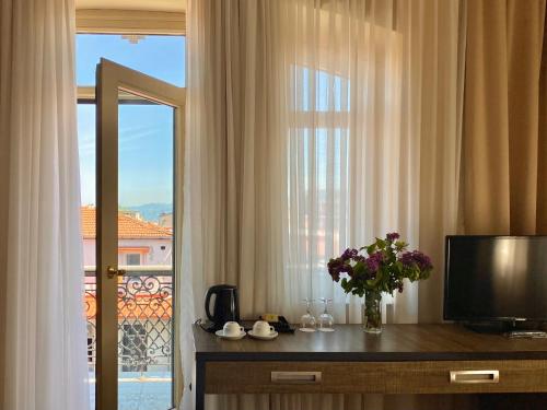 a hotel room with a window with a vase of flowers at Boutique Hotel O. Galogre in Batumi