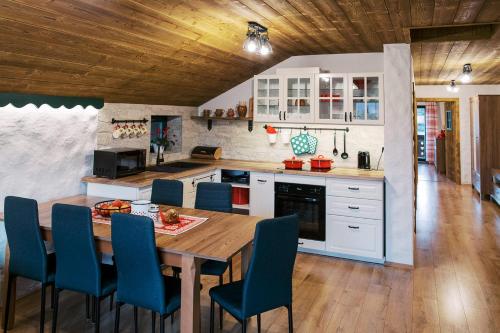 a kitchen with a wooden table and blue chairs at Apartmán Elenka in Zuberec