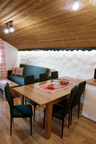 a dining room with a wooden table and chairs at Apartmán Elenka in Zuberec