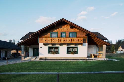 a house with a wooden roof with a yard at Apartmán Elenka in Zuberec