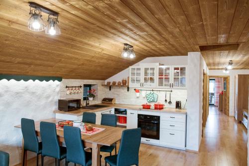 a kitchen with a wooden ceiling and a table and chairs at Apartmán Elenka in Zuberec