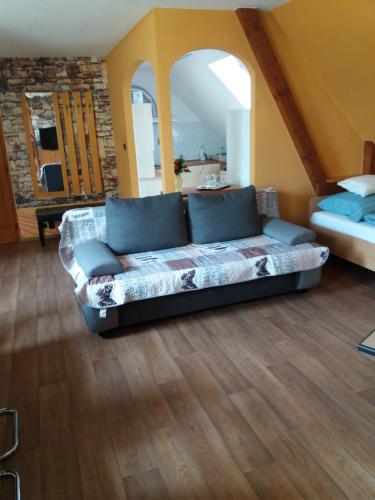 a living room with a couch and a bed at Bora Vendégház in Eger
