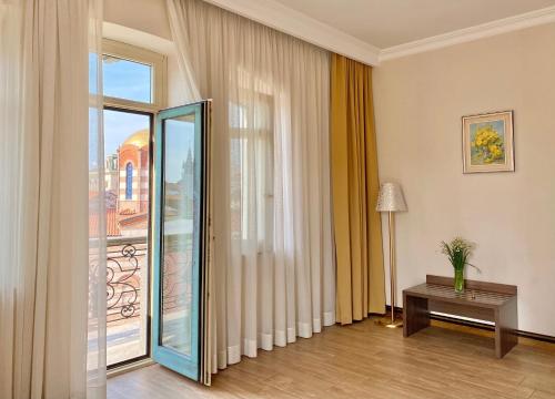 a room with a large glass door and a table at Boutique Hotel O. Galogre in Batumi