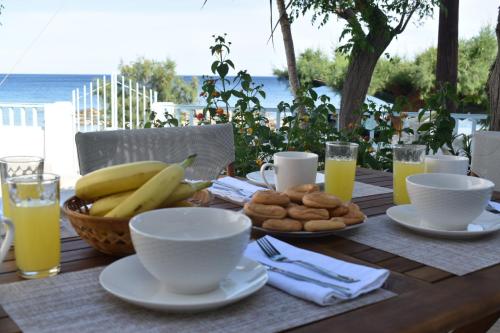 un tavolo in legno con colazione a base di banane e biscotti di Casa al mare a Archangelos