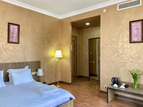 a bedroom with a bed and a table with a lamp at Boutique Hotel O. Galogre in Batumi