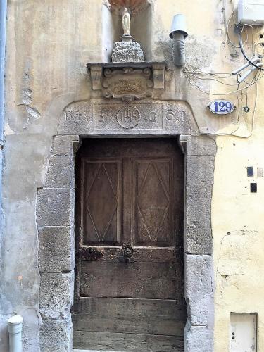 une porte en bois sur le côté d'un bâtiment dans l'établissement T2 à Menton Vue mer proche Plage, à Menton