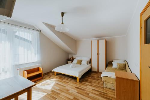a room with two beds and a table and a window at Willa Karol in Karwia
