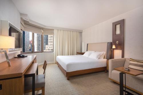 ニューヨークにあるClub Wyndham Midtown 45のベッドとデスクが備わるホテルルームです。