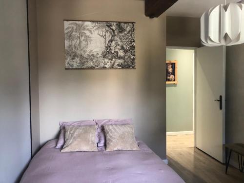 - une chambre avec un lit violet et 2 oreillers dans l'établissement Superbe appartement cosy au coeur du beaujolais, à Odenas