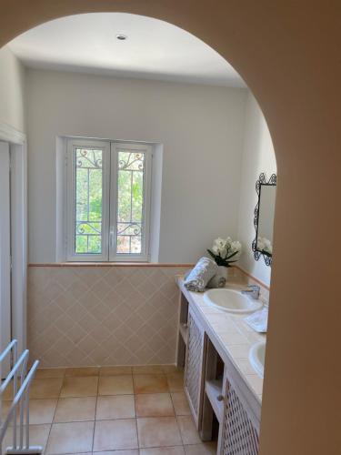 un bagno con due lavandini e una finestra di La Mauresque a Grimaud