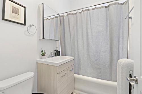 a bathroom with a sink and a shower curtain at 2BR Apartment in Great Spot with Fast Wi-Fi - Roscoe 30 in Chicago