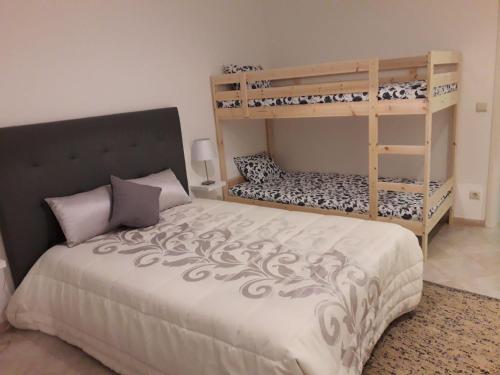 a bedroom with a bed and bunk beds with a ladder at Casa da Aldeia in Tomar