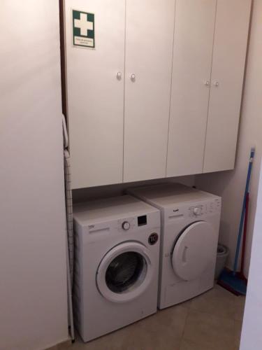 a washer and dryer in a kitchen with cabinets at Casa da Aldeia in Tomar