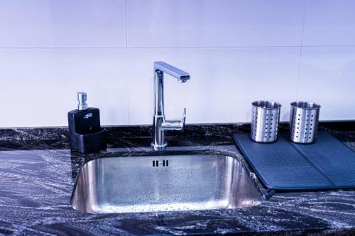 a kitchen sink with a faucet on a counter at Cozy House in the City Centre in Málaga