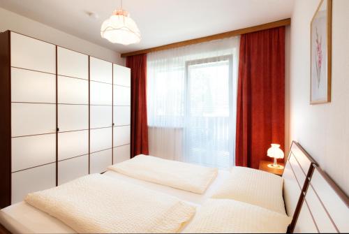 a bedroom with two beds and a window at Appartements Kanauf in Krumpendorf am Wörthersee