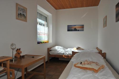 グレートジールにあるFerienwohnung Kluntjesのベッドルーム1室(ベッド2台、テーブル、窓付)
