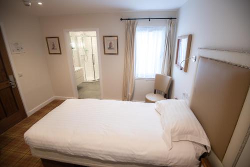 a bedroom with a large white bed in a room at The Skye Inn in Portree
