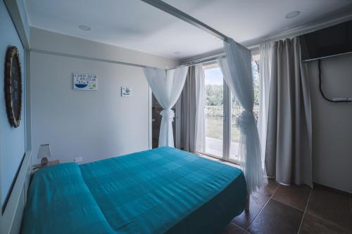 a bedroom with a blue bed and a window at Mulino Vigoli in Morciano di Romagna