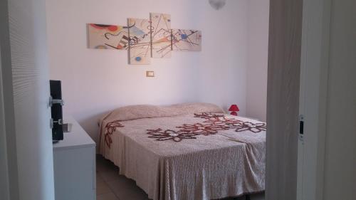 カステル・ディ・トーラにあるCasa Matilda - Casa Vacanzeのベッドルーム1室(ベッド1台付)が備わります。壁には絵画が飾られています。