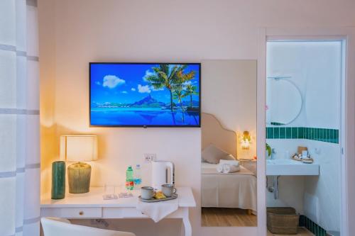 a hotel room with a bathroom with a television on the wall at La Serenata Luxury in Maiori
