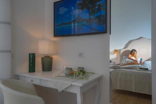 a woman laying in bed in a room with a table at La Serenata Luxury in Maiori