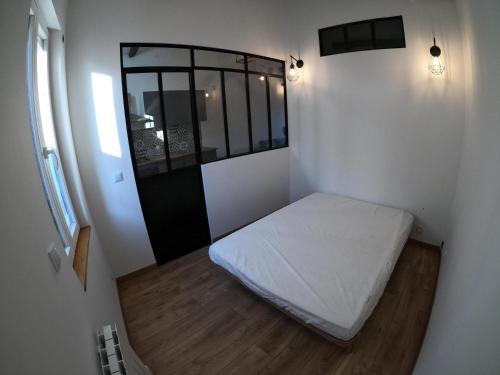 une petite pièce avec un lit et une fenêtre dans l'établissement Studio de charme pour des vacances réussies, à Corneilla-del-Vercol