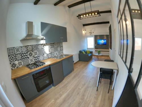 Il comprend une cuisine et un salon avec une table et une cuisinière. dans l'établissement Studio de charme pour des vacances réussies, à Corneilla-del-Vercol