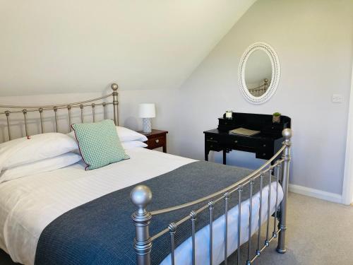 a bedroom with a bed and a table with a mirror at The Loft at Number 84 in Ballymena
