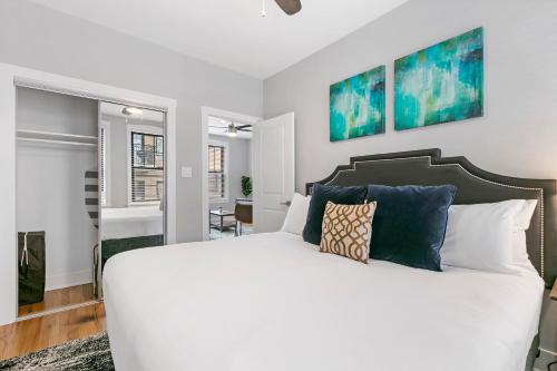 1 dormitorio con cama blanca y almohadas azules en Relaxing 1BR Apt in Lakeview near Best Restaurants - Belmont H6 en Chicago