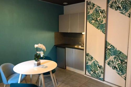 une petite cuisine avec une table et un vase de fleurs dans l'établissement Studio cocooning à 50 m du port, à Cassis