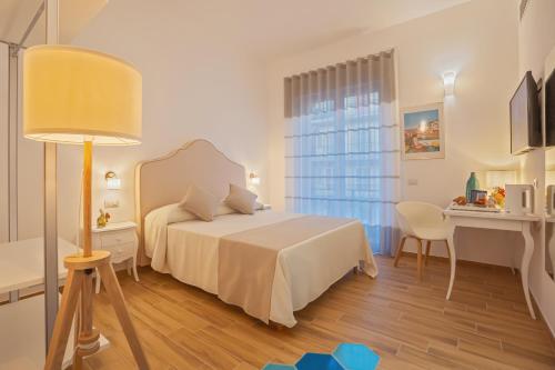 a bedroom with a bed and a desk and a lamp at La Serenata Luxury in Maiori