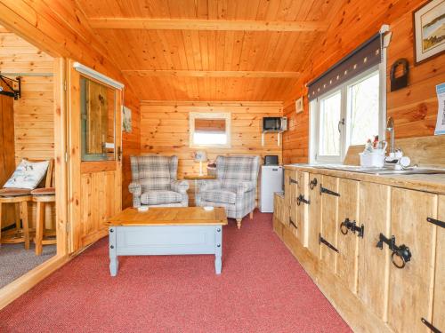 a room with two chairs and a kitchen in a cabin at Mill Cabin Denant in Haverfordwest