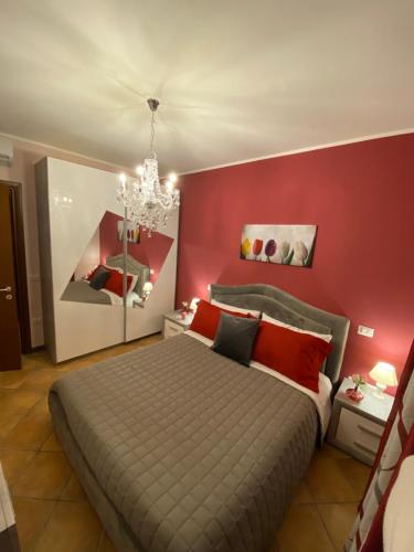a bedroom with a large bed with a red wall at CASA VACANZA FELICITA' in Porto Potenza Picena