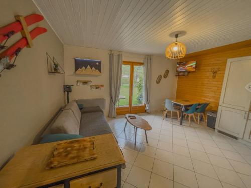 un salon avec un canapé et une table dans l'établissement Appartement Escale Les Airelles Du Lac GÉRARDMER rez de jardin, à Gérardmer