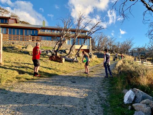 a group of people playing frisbee on a dirt road at Valhalla Perisher in Perisher Valley