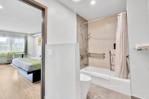 a bathroom with a bed and a tub and a toilet at Exclusivo Inn and Suites in Lakewood
