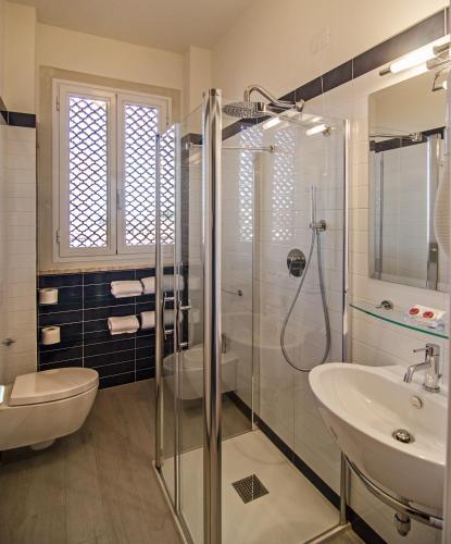 a bathroom with a shower and a toilet and a sink at Hotel Alk in Marina di Pietrasanta
