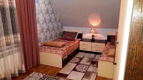 a small bedroom with two beds and a lamp at Dom Semya Deluxe Gusar in Qusar