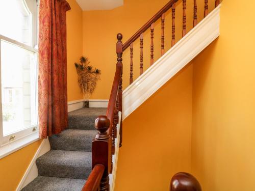 a staircase in a home with orange walls at Arlington House in Matlock