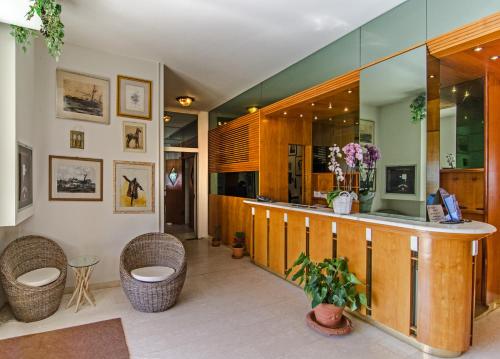 a lobby with a bar with wicker chairs at Hotel Alk in Marina di Pietrasanta