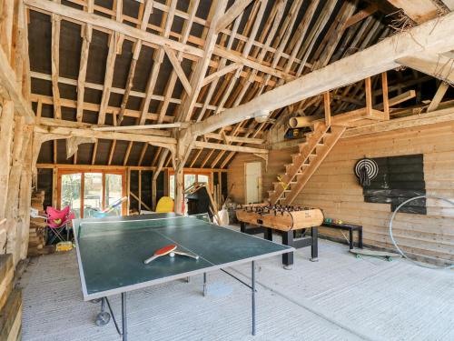 a ping pong table in the middle of a room at The Coach House in Ryde