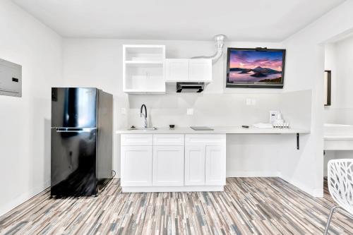 a kitchen with white cabinets and a refrigerator at Tradewinds Motel in Lakewood