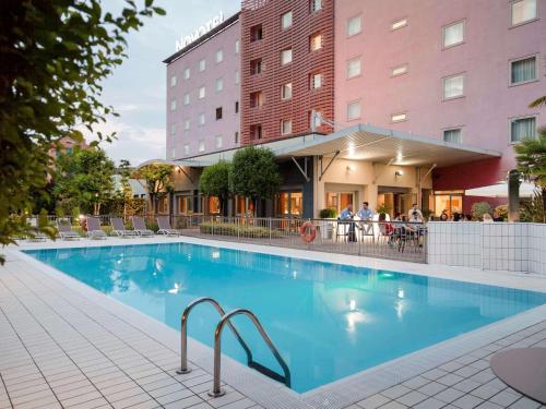 a swimming pool in front of a hotel at Novotel Brescia Due in Brescia