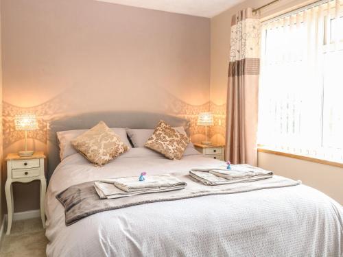 a bedroom with a bed with two towels on it at The Haven in Great Moulton