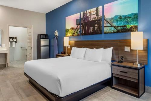 um quarto com uma grande cama branca e uma cozinha em Clarion Pointe Port Arthur-Beaumont South em Port Arthur