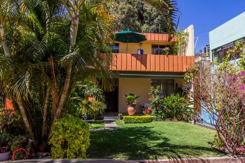 ein Haus mit einem grünen Hof mit Bäumen und Pflanzen in der Unterkunft Casa de las Palmas Guest House in Oaxaca de Juárez
