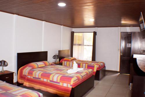 a hotel room with two beds and a window at Hotel Arenal Country Inn in Fortuna