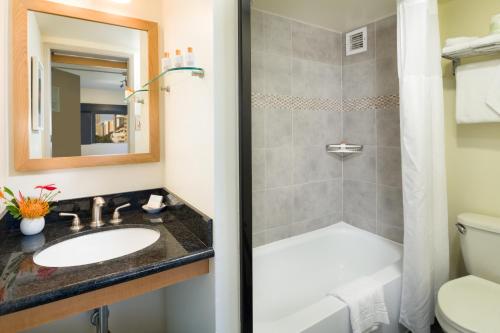 a bathroom with a sink and a shower at VIVE Hotel Waikiki in Honolulu