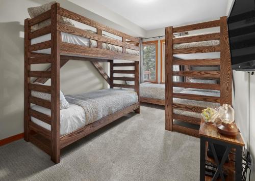 two bunk beds in a room with a staircase at Newly Renovated Grizzly Lodge, Spacious 3BR 2BA with open pool, hot tub in Canmore